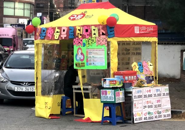 写真・図版 : ソウルには日本の公文が参入し、人気が出ている。道端や人の集まる場所で家庭学習の宣伝も（筆者撮影）