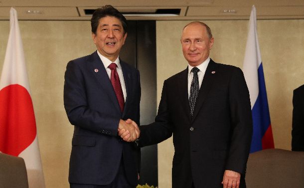 ロシアのプーチン大統領（右）と首脳会談の冒頭で握手する安倍晋三首相＝2018年11月14日、シンガポール