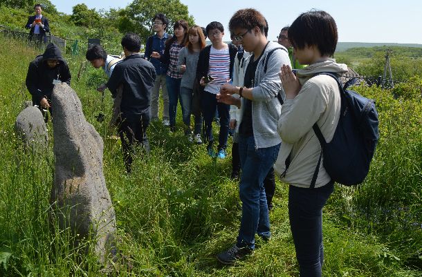 ビザなし交流による元島民や子孫らの択捉島訪問で日本人墓地にお参りする若者たち＝2016年7月、筆者撮影