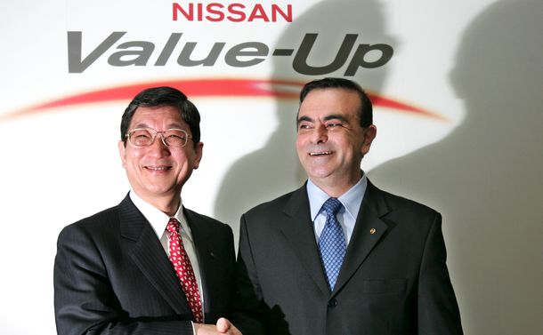 写真・図版 : 記者会見でゴーン氏と握手する志賀俊之氏＝2005年2月21日、東京・銀座
