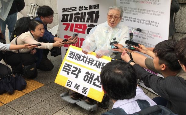 韓国外交省前で、日韓慰安婦合意に基づいて設置された財団の「即時解散」を求めてデモをする金福童さん(中央)=2018年9月3日、ソウル
