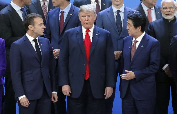 Ｇ20の記念撮影でトランプ米大統領をはさんで立つマクロン大統領と安倍首相＝2018年11月30日、ブエノスアイレス