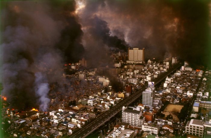 写真・図版 : 黒煙を上げて燃え上がる神戸市長田区。道路は阪神高速道路＝1995年1月17日、朝日新聞社ヘリから