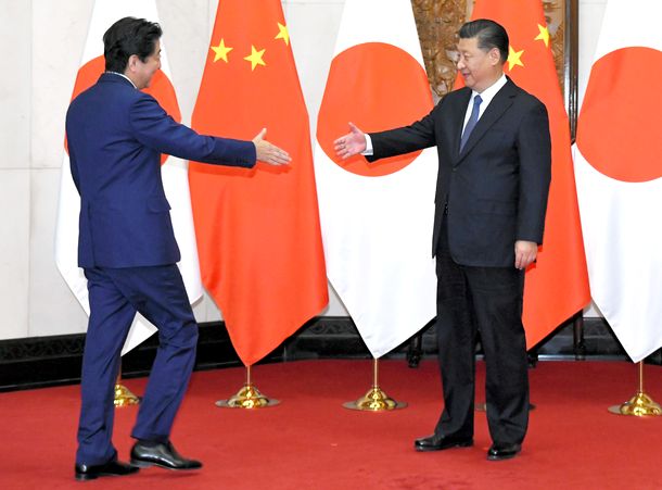 写真・図版 : 会談を前に握手する安倍首相（左）と中国の習近平国家主席＝2018年10月26日、北京の釣魚台国賓館 