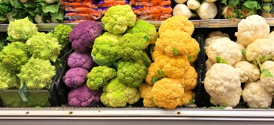 写真・図版 : スーパーマーケットに並ぶ色とりどりのカリフラワー。一番右の白から紫までがカリフラワーで、一番左はロマネスコ＝米国シアトルのメトロポリタンマーケットにて著者撮影