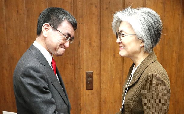 写真・図版 : 韓国の康京和外相（右）と握手する河野太郎外相＝2019年1月23日、スイス・ダボス