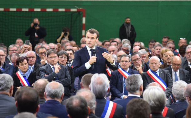 地方の首長らに語りかけるマクロン仏大統領（中央）＝2019年1月15日、フランス・グランブルテルルド