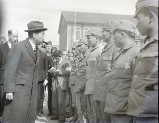 写真・図版 : 浦賀の引揚援護所でニューギニアから復員した部隊の兵士と言葉を交わす昭和天皇=1946年2月20日