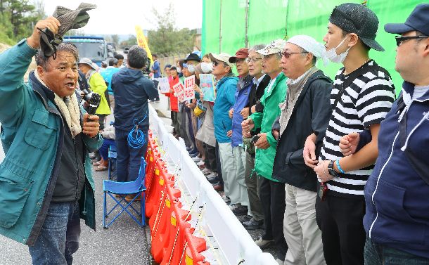 写真・図版 : 沖縄県民投票の翌日、米軍キャンプ・シュワブ前でトラック進入を阻止しようとする人たち＝2019年2月25日午前9時26分、沖縄県名護市