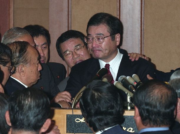 内閣不信任案に賛成票を投じると発言した加藤元幹事長は、合同総会に出席した議員から押しとどめられ、涙を浮かべた＝2000年11月20日、東京都港区