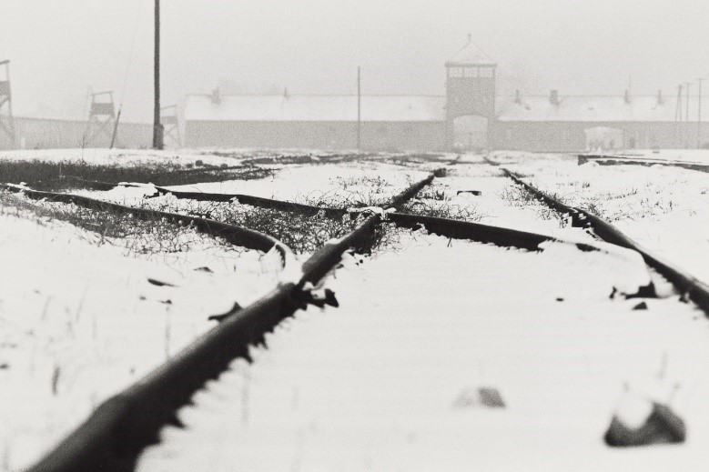 写真・図版 : 強制収容所の「死の門」と呼ばれたSS（ナチス親衛隊）の中央衛兵所が前方正面に見える（アウシュヴィッツ　ビルケナウ、1987年）©Yoshino Oishi