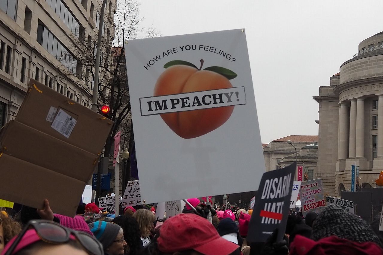 写真・図版 : ワシントンで今年1月19日に行われた「ウィメンズマーチ」で、トランプ氏に対する弾劾（Impeach）を求めるプラカードを掲げて行進する市民（沢村撮影）