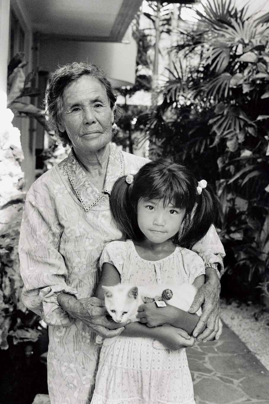 写真・図版 : 宮平春子（1926年生）は、父親から「自決しよう」といわれたが、山に逃げた。兄一家6人、親族の17人、特攻隊で2人の兄が亡くなった。子ども4人、孫7人。孫の愛（6）と里帰りした座間味島で（2007年）©Yoshino Oishi