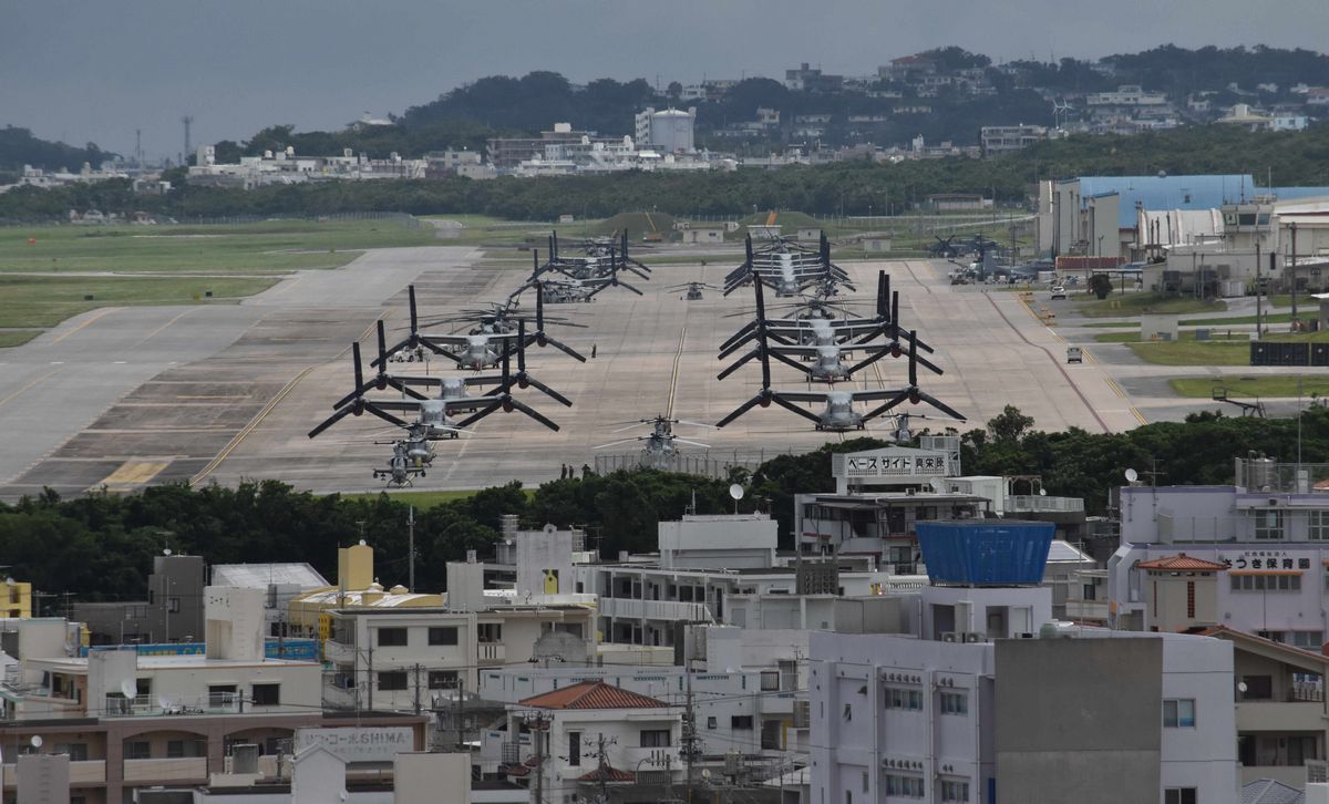 写真・図版 : 沖縄県宜野湾市の市街地に囲まれた米軍普天間飛行場。輸送機オスプレイが並ぶ=4月。朝日新聞社