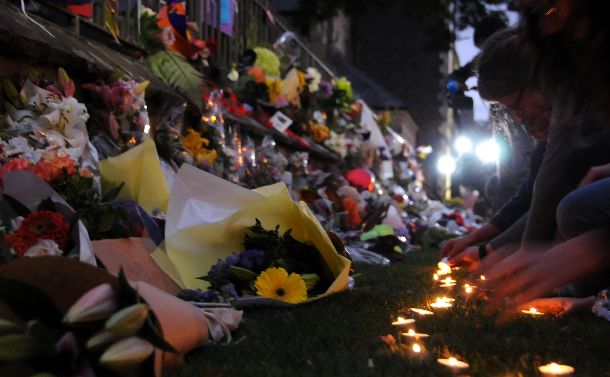写真・図版 : 銃乱射テロ事件の後、クライストチャーチの公園花やロウソクを捧げる人たちが夜になっても途絶えなかった＝2019年3月16日
