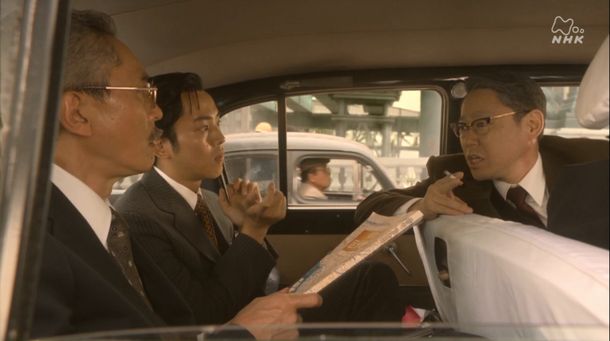 写真・図版 : 大河ドラマ「いだてん～東京オリムピック噺（ばなし）～」第6話から。主人公の一人（右）が車内で喫煙するシーン 