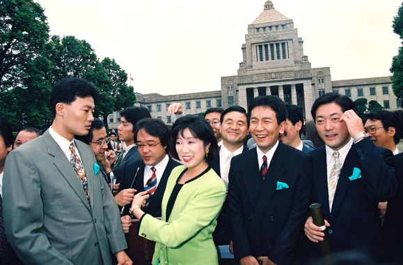 写真・図版 : 初登院し、国会議事堂を背にカメラにポーズをとるた日本新党の議員たち。枝野氏の姿も＝1993年8月5日