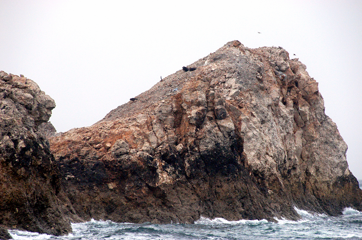 写真・図版 : 米軍が使う鳥島射爆撃場。削り取られた岩肌には砲弾とみられる物体が突き刺さる＝2009年6月、沖縄県久米島町 