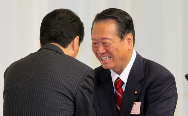写真・図版 : 民主党代表に再選された菅直人首相（左）と握手する小沢一郎氏＝2010年9月14日、東京都港区