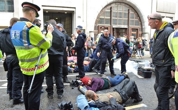 気候変動対策を訴え、路上に寝転ぶ環境活動家ら＝2019年４月25日、ロンドン中心部の金融街シティー、下司佳代子撮影