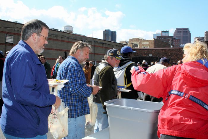 写真・図版 : 教会のボランティアから食事の配給を受けるホームレスの人たち＝アメリカ・オハイオ州クリーブランド