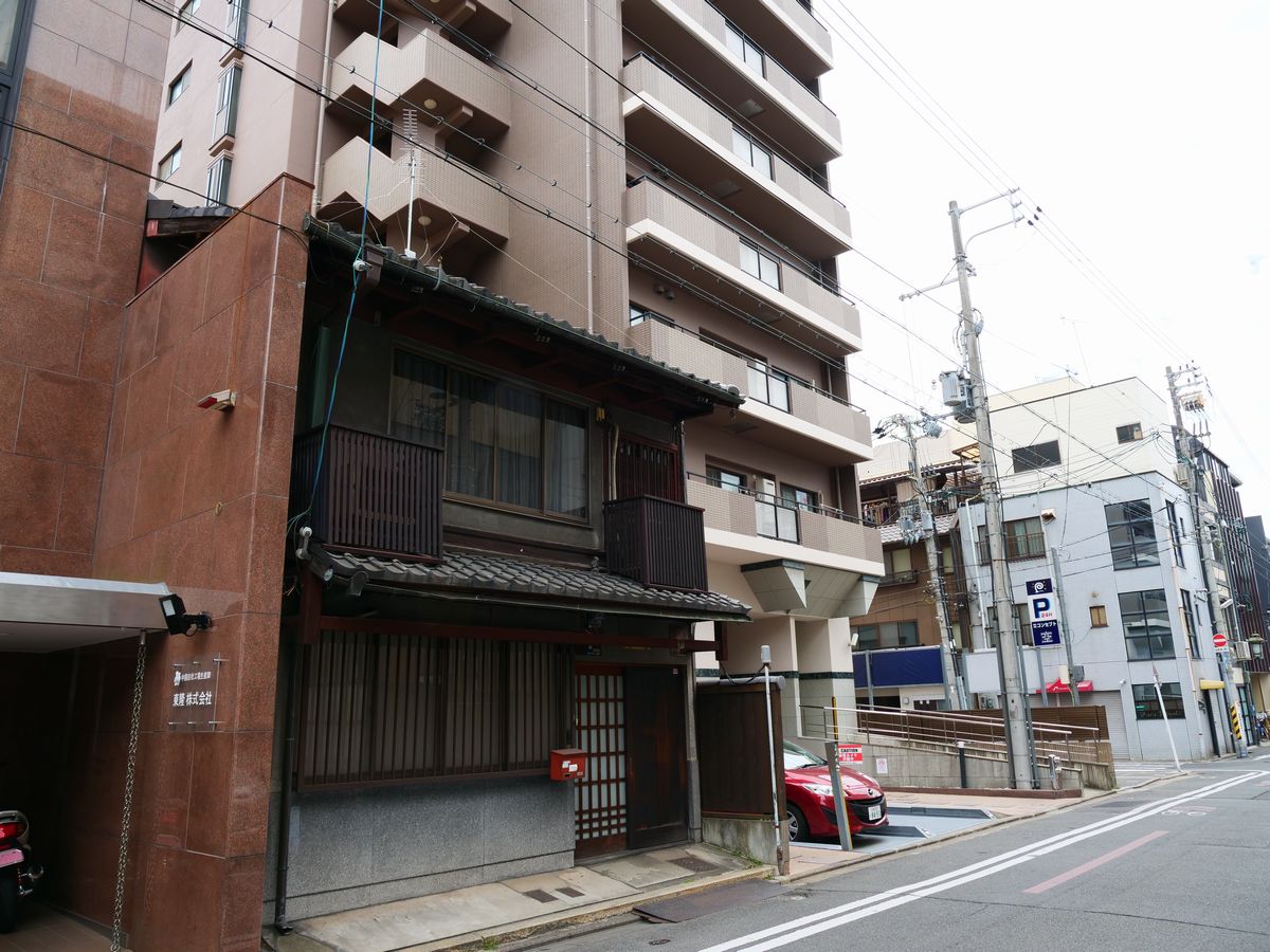 写真・図版 : 町家とマンション、駐車場が交互に残る。いまの京都を象徴する街並みだ