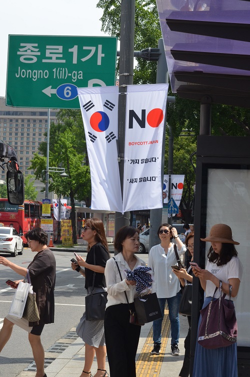 写真・図版 : ソウル市内の目抜き通りに一時設置された「ボイコット・ジャパン」の旗＝2019年8月6日