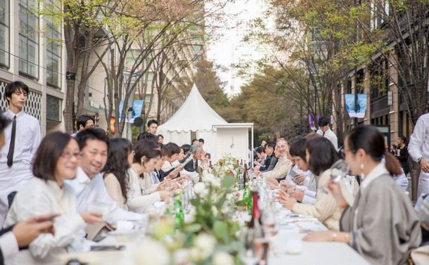 写真・図版 : MICE誘致における公的空間活用例としても開催されたイベント。丸の内仲通りの路上に設置された長さ25メートルのロングテーブルで料理を堪能した＝三菱地所提供
