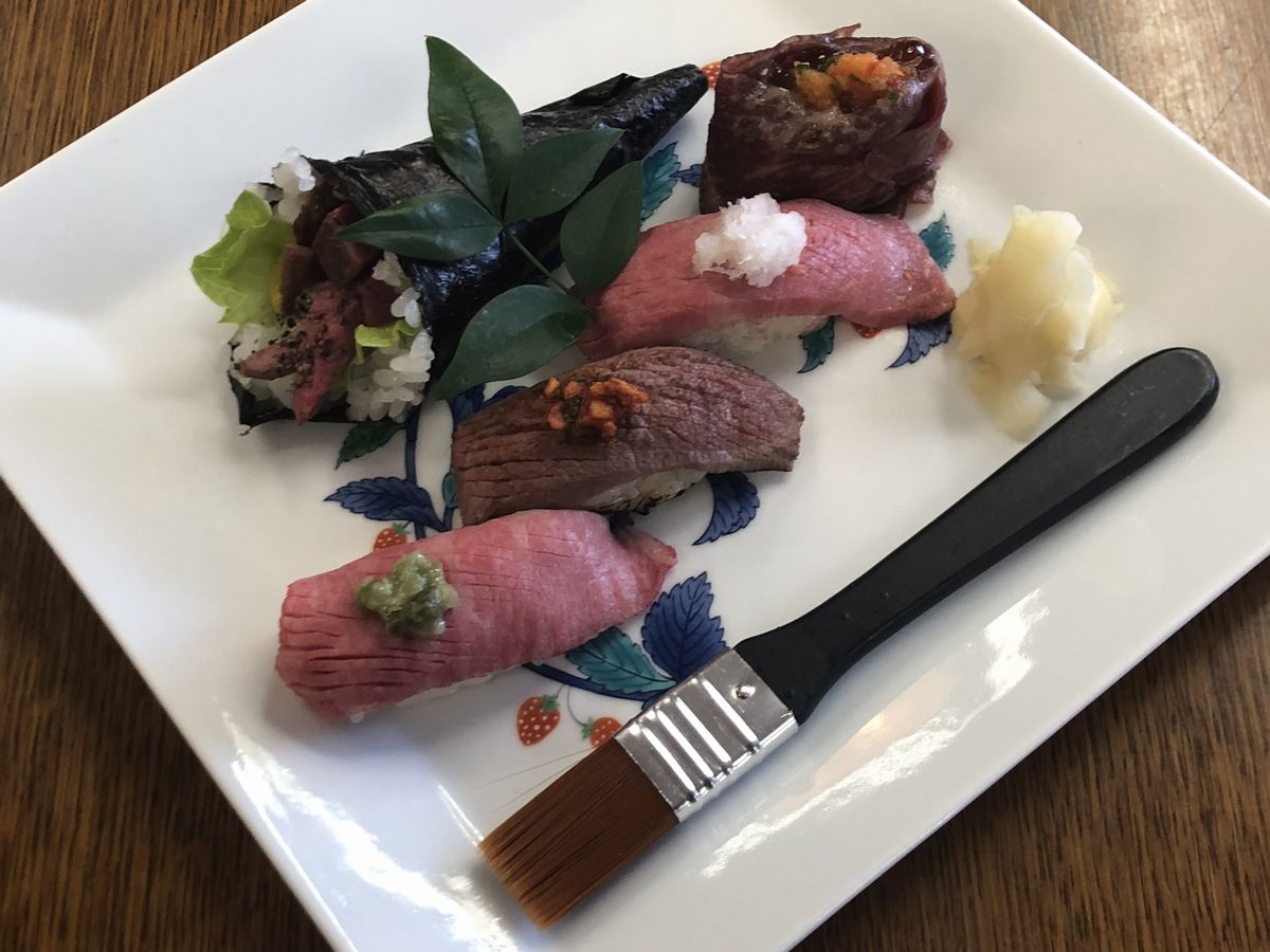 写真・図版 : 大分で考案された「おおいた和牛寿司」。外国人でも食べやすいように、しょうゆやたれを塗るはけも添えられていた