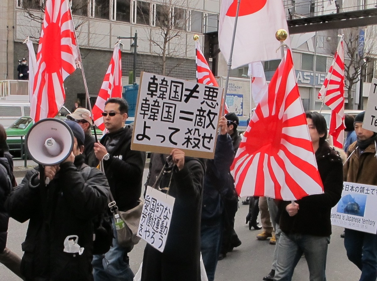 写真・図版 : 韓国人を排撃するヘイトデモでは、日の丸よりも旭日旗が好んで掲げられることが多い＝2013年2月17日、東京・新大久保