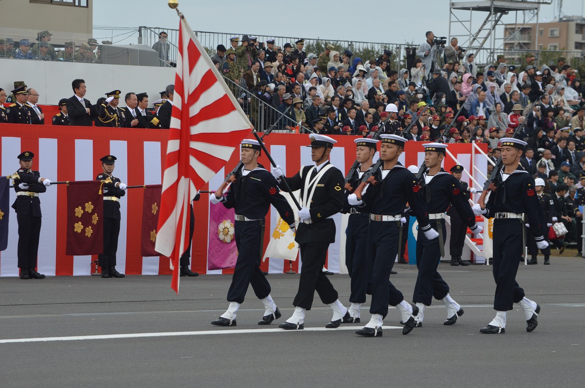 写真・図版 : 自衛隊観閲式で旭日旗を掲げ安倍首相らの前を行進する海上自衛隊員ら＝2018年10月14日、埼玉県朝霞市