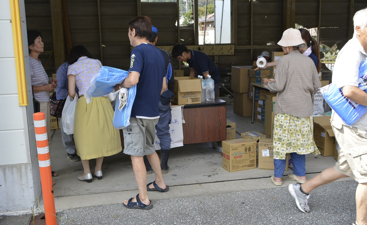 写真・図版 : 町に寄付された飲料水やおむつ、粉ミルクなどの支援物資を受け取る人たち=2019年9月12日、千葉県鋸南町役場