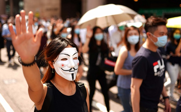 写真・図版 : 覆面禁止法に反対するデモ隊。多くの参加者が顔を隠すマスクなどをして声を上げた＝2019年10月4日、香港