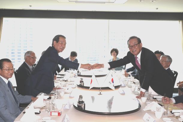 写真・図版 : 昼食会を前に握手する日韓議員連盟の額賀福志郎会長（左）と韓国の徐清源（ソ・チョン・ウォン）国会議員＝2019年7月31日、東京都内のホテル