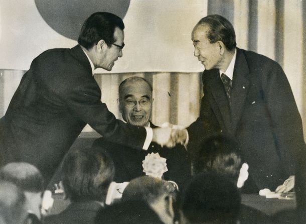 写真・図版 : 日韓議員連盟総会ぼ開会式で金鐘泌会長（左）と握手する福田赳夫首相。中央は船田中会長＝1977年2月16日、東京都内のホテル