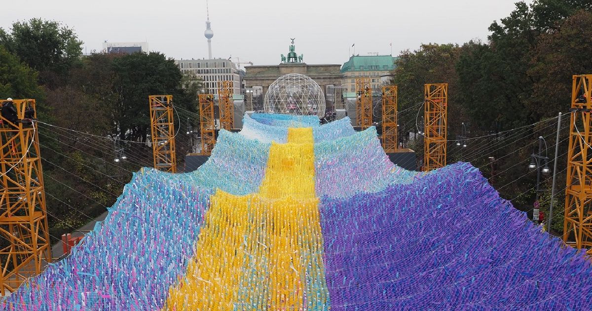 写真・図版 : ベルリンの壁崩壊から30年に合わせ、世界各国の約3万人から寄せられたメッセージがブランデンブルク門の前に飾られた＝2019年11月1日、ベルリン
