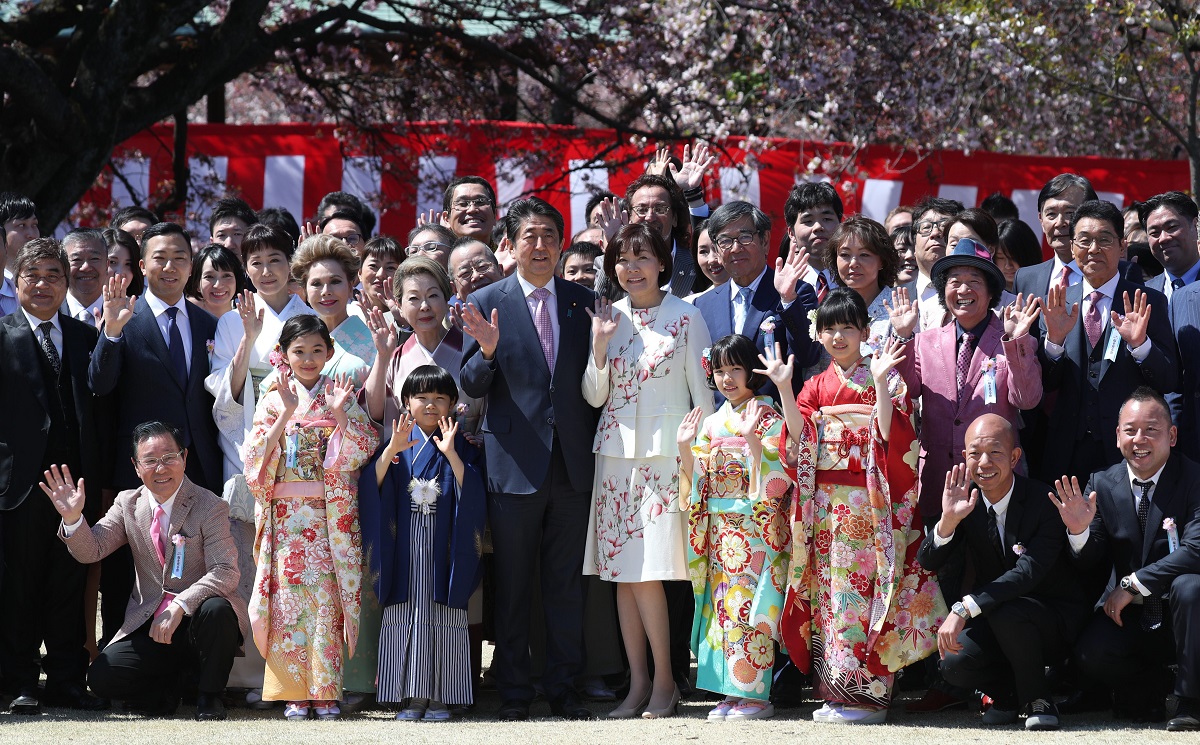 写真・図版 : 安倍首相、昭恵夫人を囲んで記念撮影する「桜を見る会」の参加者ら＝2019年4月13日、東京・新宿御苑