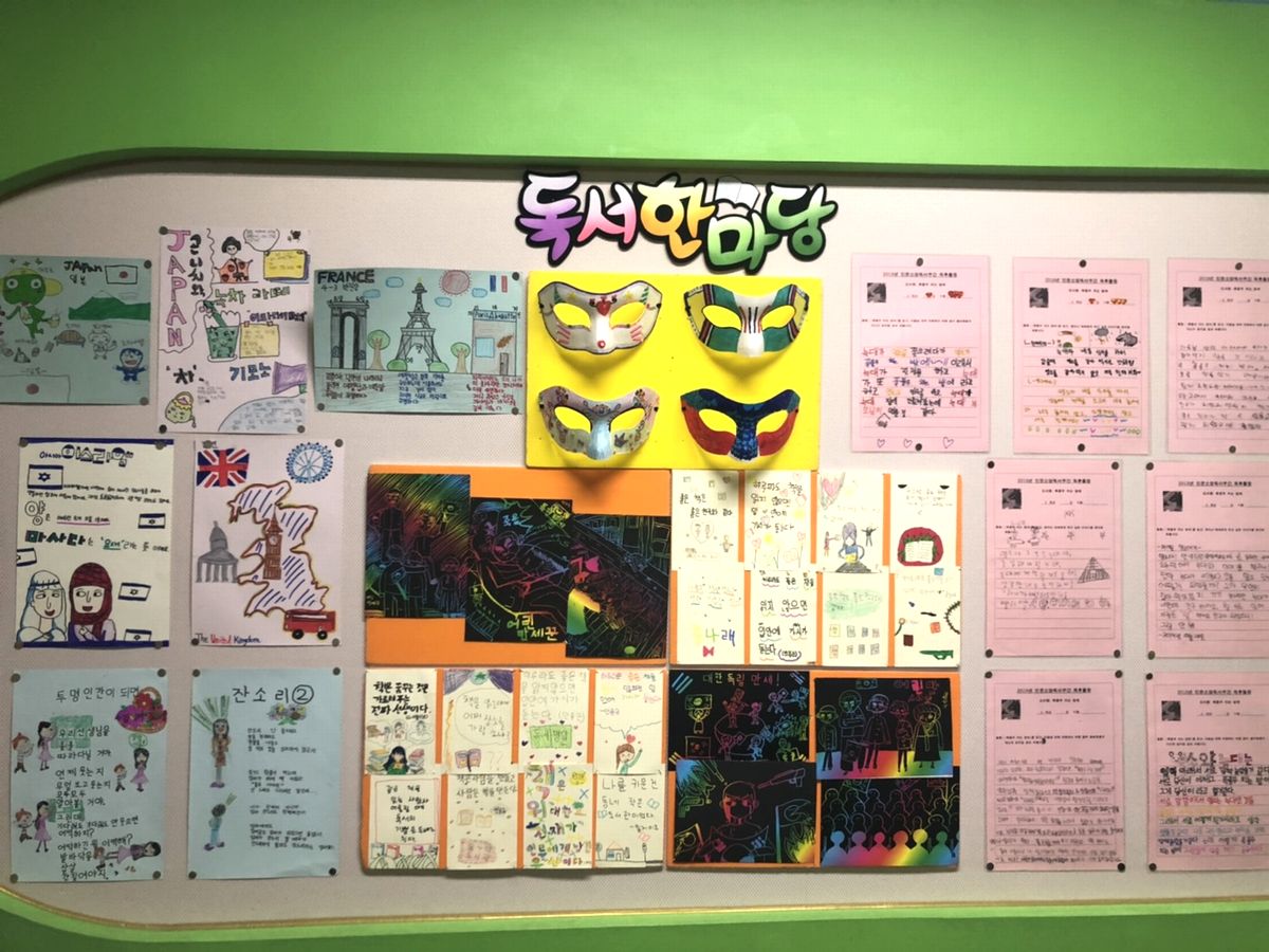 写真・図版 : 韓国の公立小学校の図書室の掲示板。左側には学習した国の事が絵と共に飾られている。イスラエル、フランス、イギリス、日本。