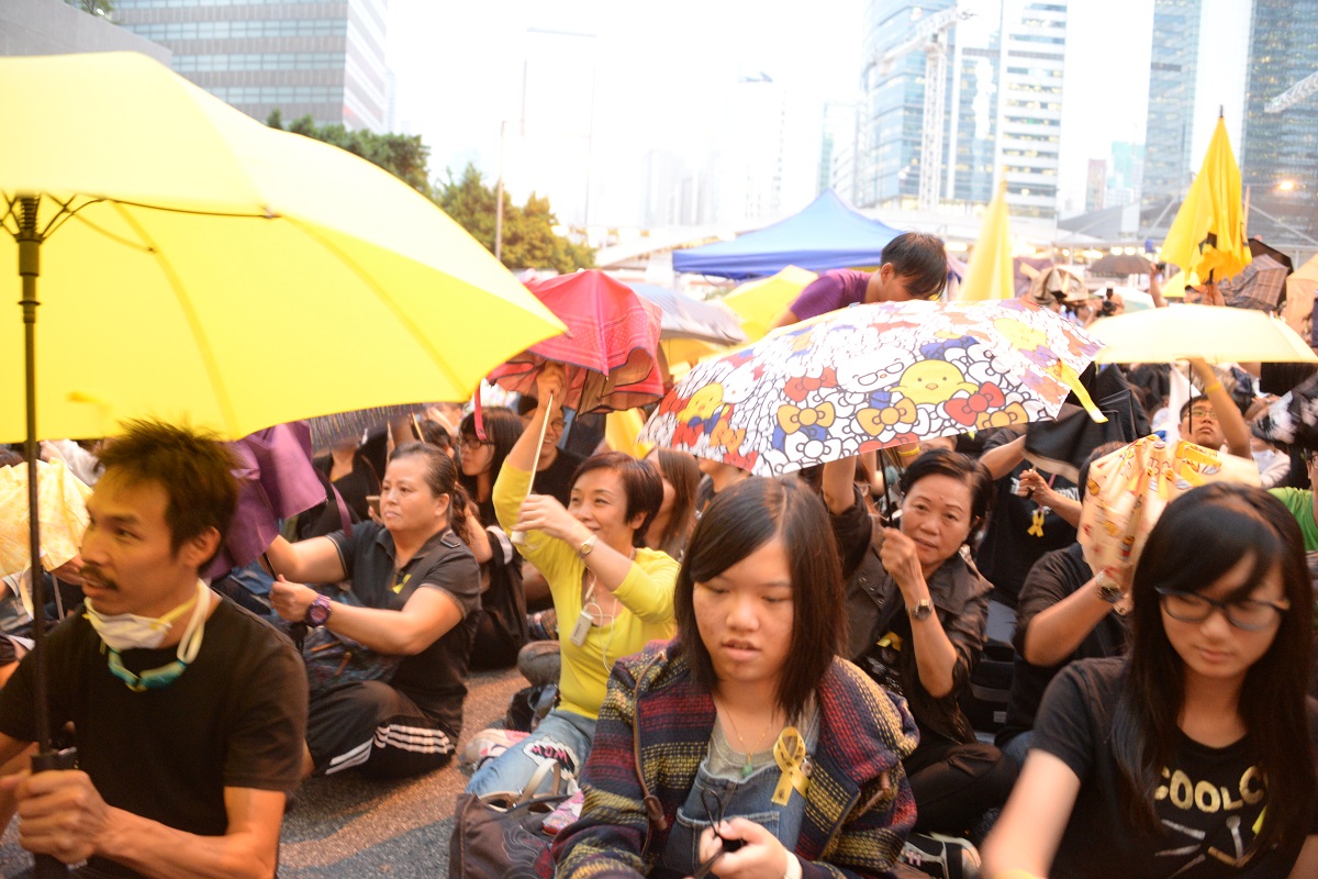 写真・図版 : 香港の中心街・金鐘の路上を占拠し、運動のシンボルとなった雨傘を差す人々＝2014年10月28日