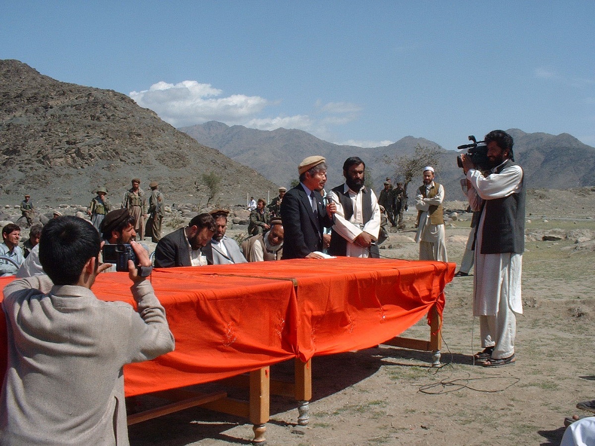 写真・図版 : 潅漑用水路の起工式で話す中村哲さん＝2003年3月、アフガニスタン・ダラエヌール村近くで