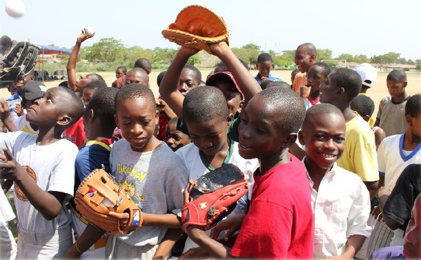 写真・図版 : ファンケル社の支援により多くの野球道具が届けられた。テマ市で行った野球道具寄贈式で道具を受けとる子供たち
