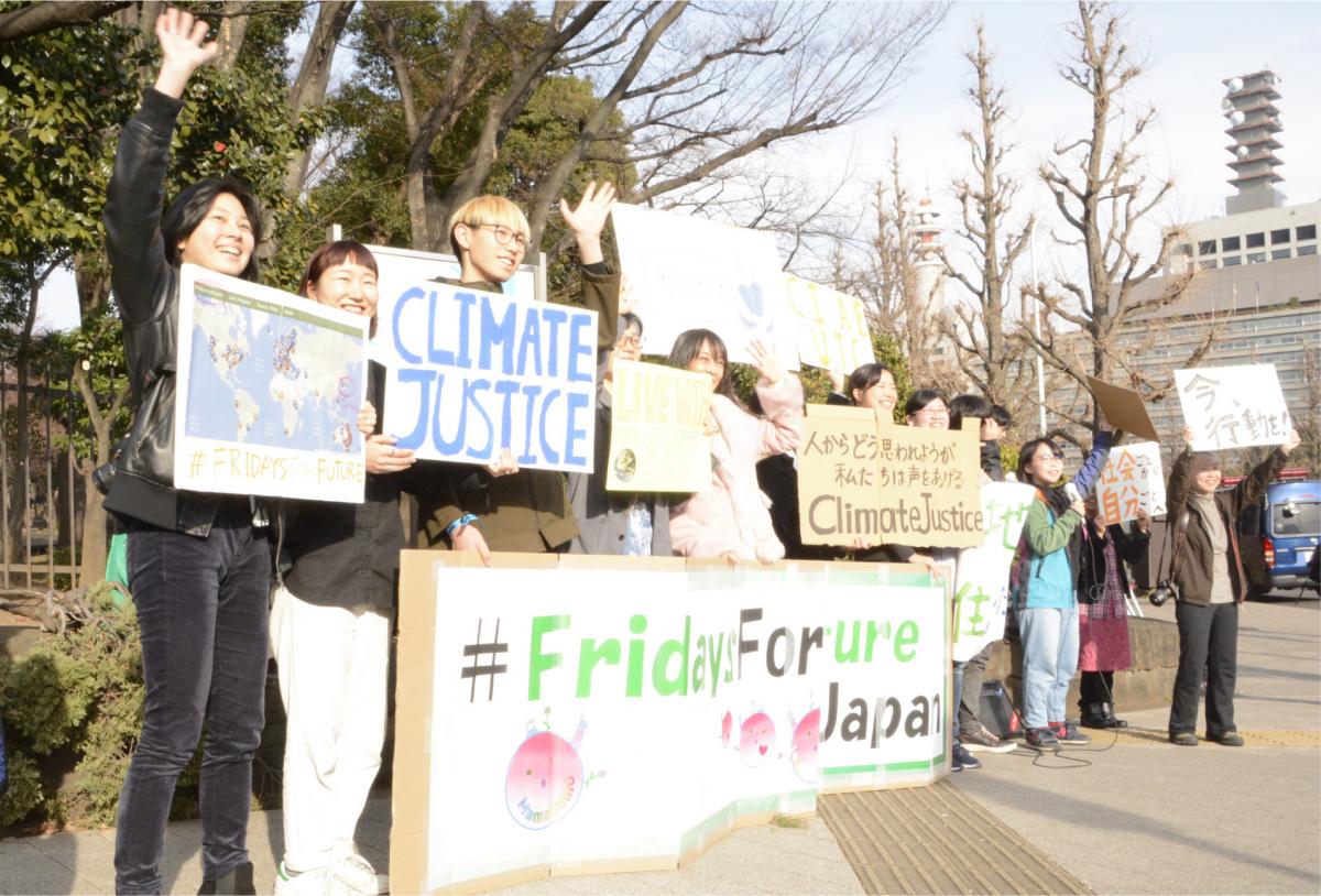 写真・図版 : 「Fridays For Future Japan」と記されたボードを示し、温暖化対策を訴える学生ら＝2019年2月22日、東京都千代田区の国会議事堂正門前