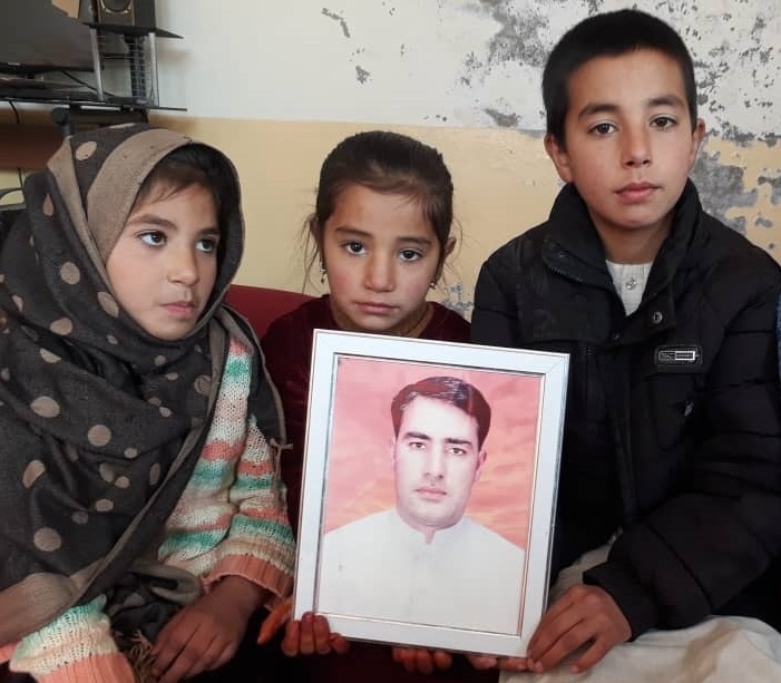 銃撃事件で中村哲医師とともに亡くなったマンドザイさんの遺影を持つ子どもたち=2019年12月13日、カブール、ジャヘド・アハディ撮影