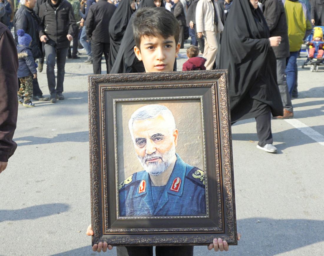 写真・図版 : 米軍に殺害された革命防衛隊のソレイマニ司令官の写真を掲げる子ども＝2020年1月3日、テヘラン、パンテア・バセッグ撮影