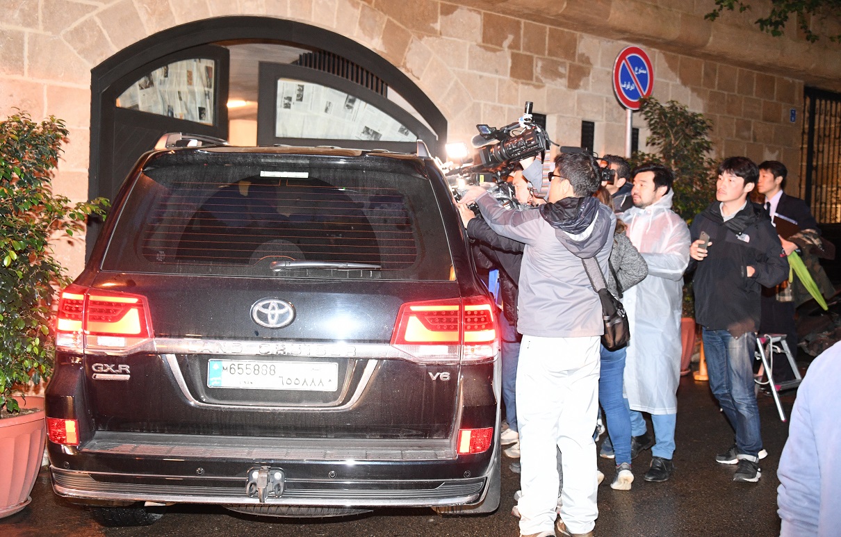 写真・図版 : レバノンの首都ベイルート中心部にあるカルロス・ゴーン被告の自宅に出入りする車を取材する日本の報道陣