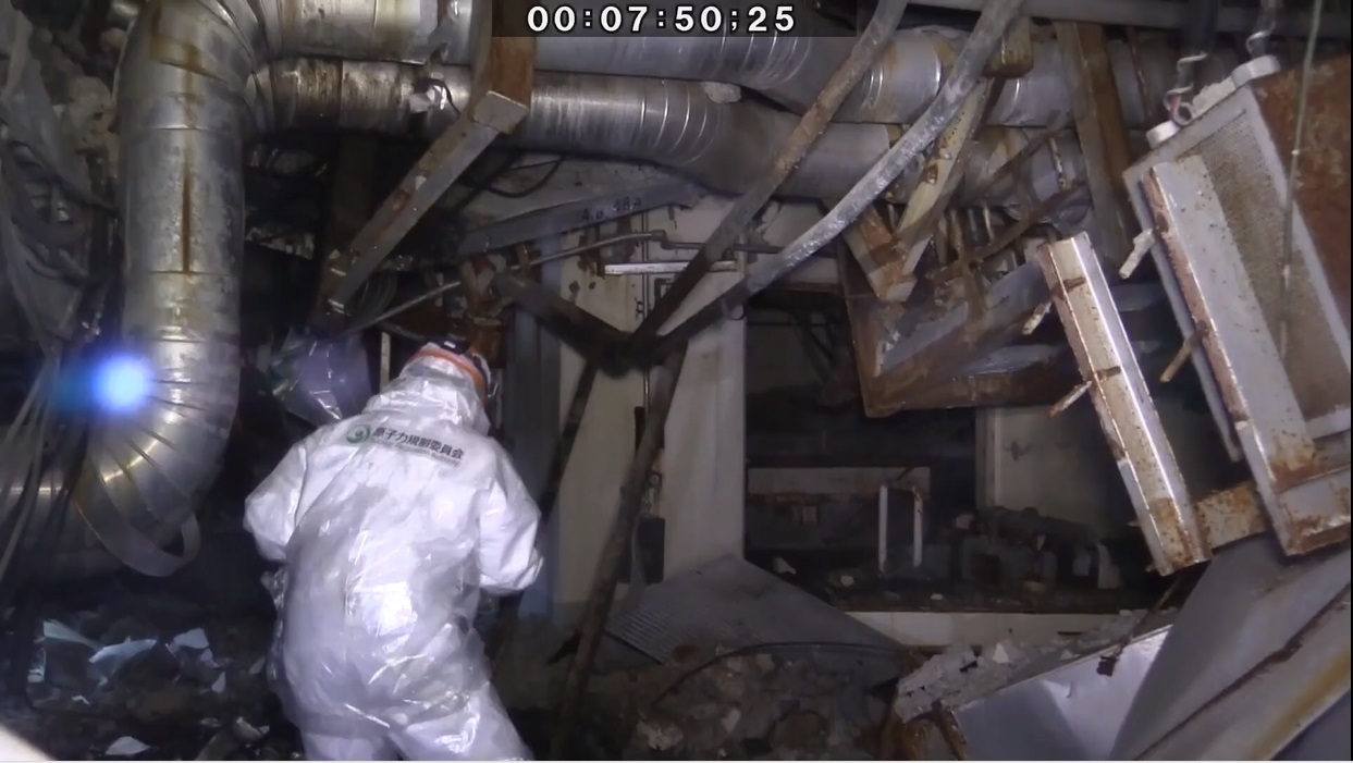 写真・図版 : 福島第一原発3号機原子炉建屋の調査をする原子力規制委員会の職員。設備が大きく破損している＝2019年12月12日、原子力規制委員会提供の動画から 
