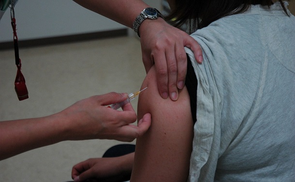 写真・図版 : 子宮頸がんのワクチンを打つ女性