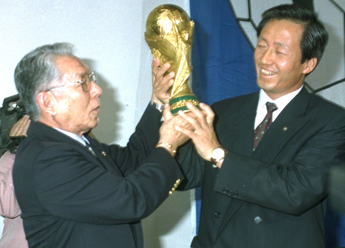 写真・図版 : サッカーW杯共催が決まり、日韓サッカー協会会長の長沼健（左）、鄭夢準両氏が一緒にトロフィーを掲げた＝1996年5月31日、スイス・チューリヒ