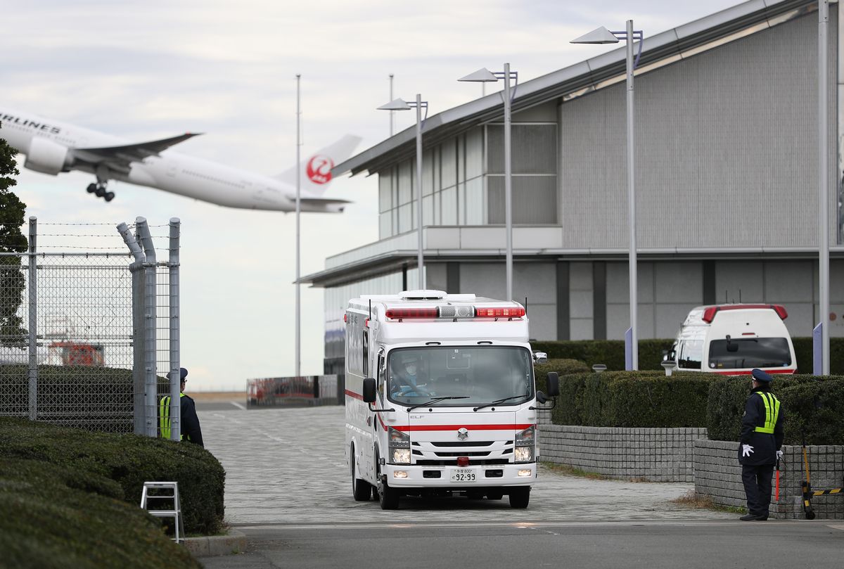 写真・図版 : 武漢からのチャーター機で到着した乗客を搬送する救急車＝2020年1月31日、東京都大田区
