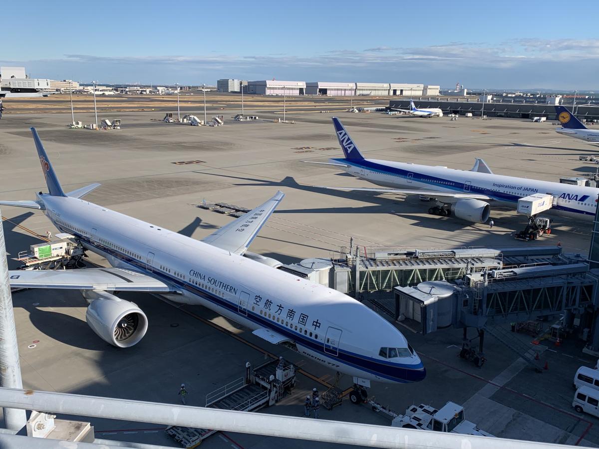 写真・図版 : 羽田空港に駐機する中国の旅客機。ボーダーレスになり、多くの人が行き来する現代では、鎖国のような水際対策には限界がある＝2020年1月31日、岩崎撮影